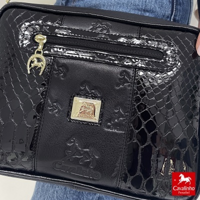 Carteira ou bolsa preta com padrão em relevo e fecho dourado