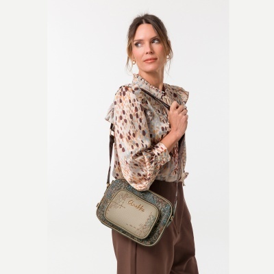 Bolsa rectangular bege e verde com alça castanha e blusa estampada em tons terra