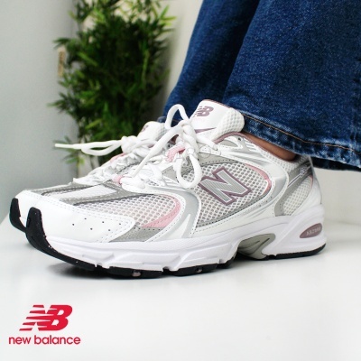 Ténis New Balance branco com detalhes cinza e rosa usados com jeans