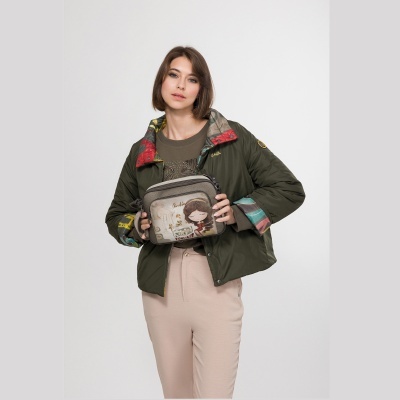 mulher com casaco acolchoado verde e bolsa cinzenta com desenho e texto