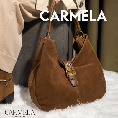 Mala castanha de camurça com alças de couro e detalhes dourados sobre tapete branco.