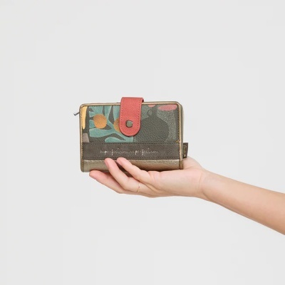 Carteira feminina com padrão floral, fecho rosa e texto branco, segurada por mão feminina sobre fundo branco.