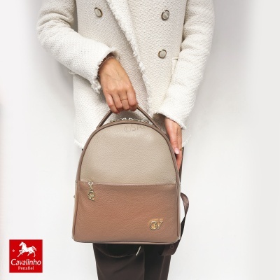 Mochila cavalinho bicolor castanho com logo dourado, em mãos