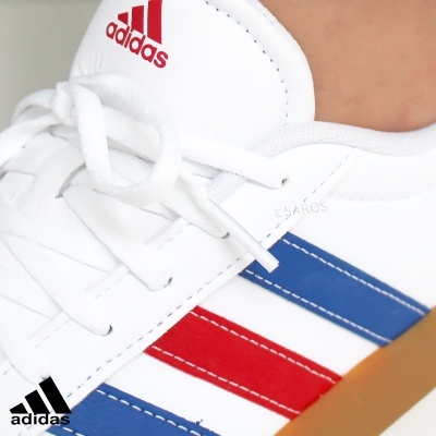 Ténis branco Adidas com riscas azul e vermelho e sola castanha