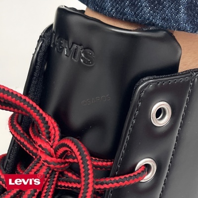 Bota preta com atacadores vermelhos e pretos e logo Levi's