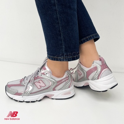 Ténis New Balance 530 cinzentos com detalhes em rosa e prata.