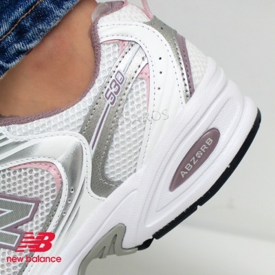 Ténis desportivo New Balance branco com detalhes rosa e cinza e sola com inscrição ABZORB