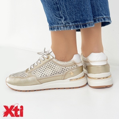 Ténis dourados e brancos da marca Xti com sola branca e risca dourada