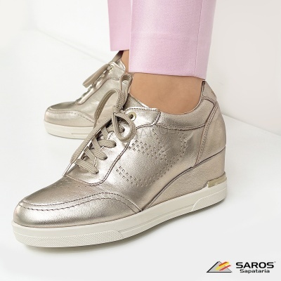 Ténis prateados metálicos com sola branca e atacadores, usados com calças rosa clara