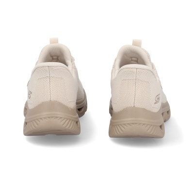 Ténis desportivos bege claro vistos de trás sobre fundo branco