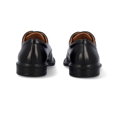 Par de sapatos sociais pretos em couro vistos de trás.