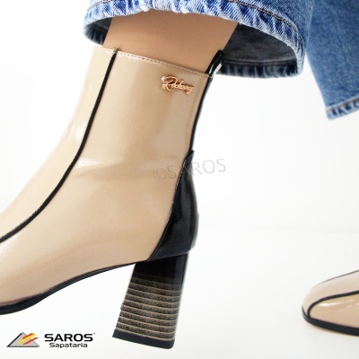 Bota feminina bege com detalhe preto e salto médio, usada com calça jeans azul