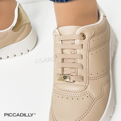 Ténis creme com atacadores e sola branca usado por pessoa com jeans em fundo branco