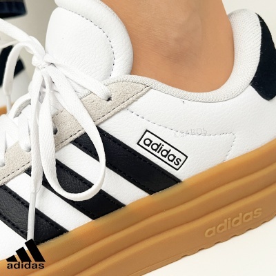 Ténis Adidas brancos com riscas pretas e sola castanha