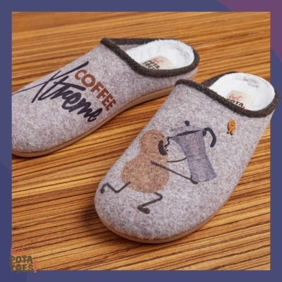 Chinelos cinza com bordas escuras e estampas de café sobre fundo de madeira.