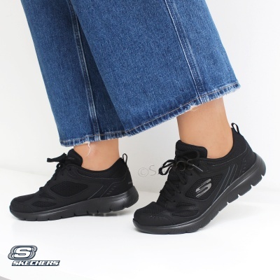 Tênis pretos Skechers com sola preta e calças de ganga azuis