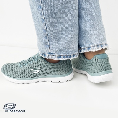 Sapatilhas Skechers verdes água com sola branca usadas com jeans azuis.