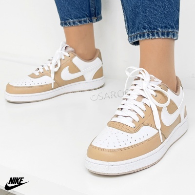 Tênis Nike branco e bege com atacadores brancos usado com jeans azuis