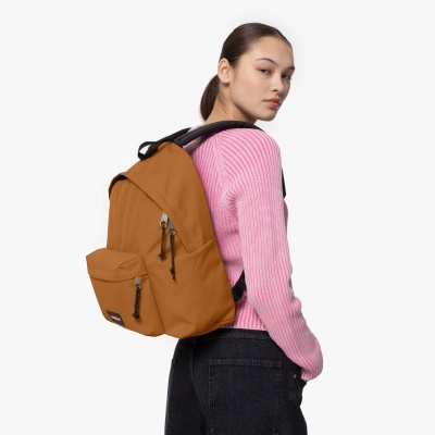 Mulher de costas com mochila castanha e camisola rosa