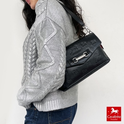 Mala de couro preta com padrão em relevo e camisola cinza tricotada