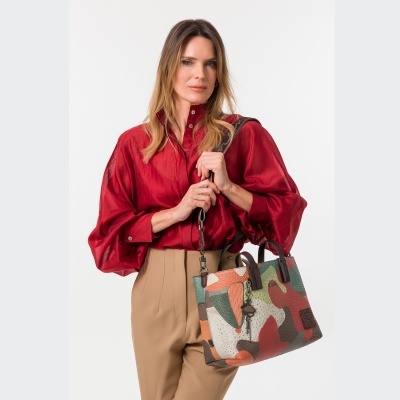 Mulher com camisa vermelha e bolsa camuflada a segurá-la