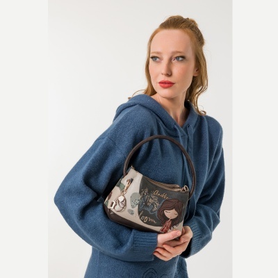 Mala de mão Anekke com padrão ilustrado segurada por mulher com camisola azul