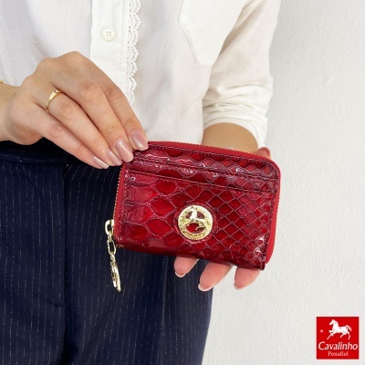 Carteira pequena vermelha com padrão de pele de crocodilo e detalhe dourado circular
