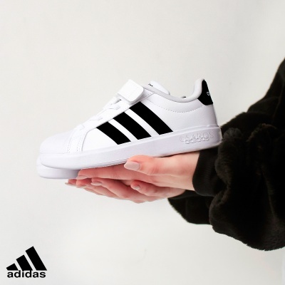 Sapatilha adidas branca com riscas pretas e fecho de velcro
