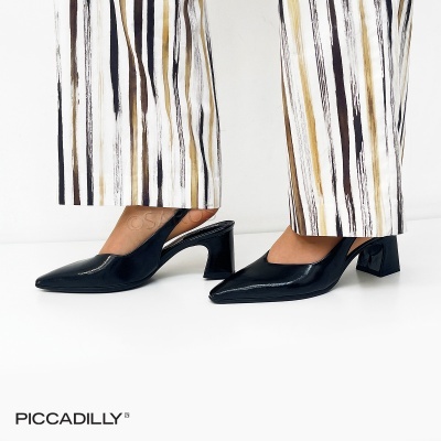 Sapatos pretos de salto médio com calças brancas de riscas verticais