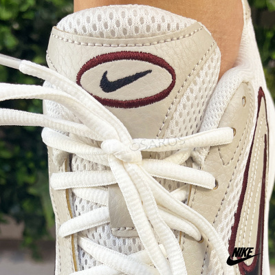 Ténis branco com detalhes em couro bege, atacadores brancos e logo Nike bordado