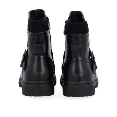 Botas pretas de pele vistas de trás com sola preta e fivela lateral