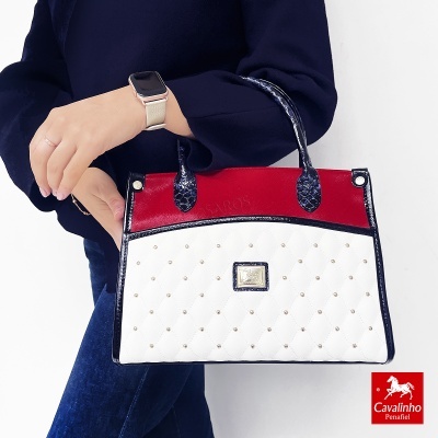 Mala de mão feminina branca, vermelha e preta com padrão acolchoado e detalhes brilhantes.