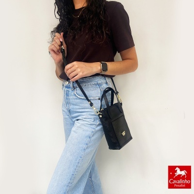 Mulher com mala preta de pele e roupa casual com fundo branco