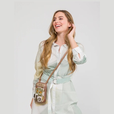 Mulher a usar vestido branco e mala pequena tiracolo com padrão colorido