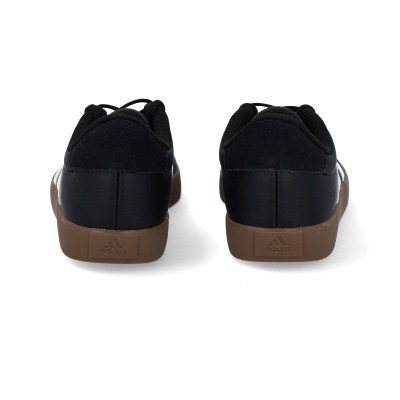 Par de ténis Adidas pretos com sola castanha vistos de trás