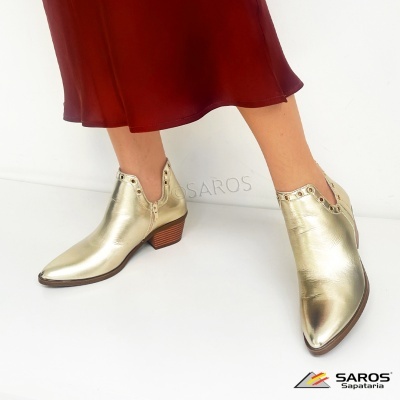 Botins dourados em couro com tacão baixo e rebites metálicos