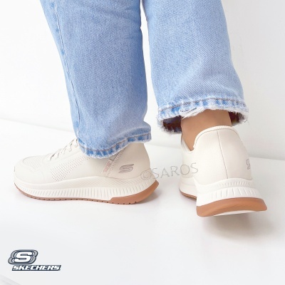 Ténis Skechers bege claro com sola castanha e branca usados com jeans azuis claros