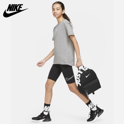 Pessoa jovem vestindo roupa e acessórios Nike, com mochila, em fundo branco