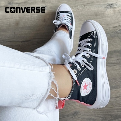 Ténis Converse All Star pretos e brancos com detalhes rosa, calças brancas rasgadas, chão madeira clara