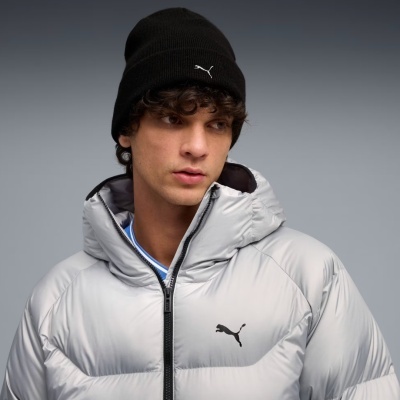 Homem com casaco acolchoado cinza e gorro preto, ambos com logos PUMA.