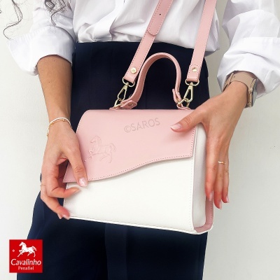 Mala de mão feminina rosa e branca com detalhe de cavalo em relevo.