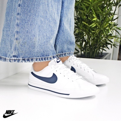 Tênis Nike branco com detalhes azuis escuros e calças de ganga largas
