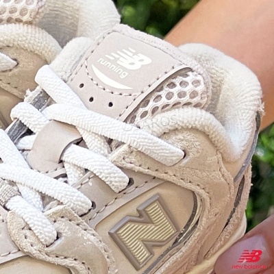 Sapatilha New Balance bege clara com atacadores brancos e logótipo NB running