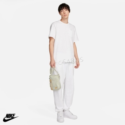 Homem com roupa e acessórios desportivos brancos segurar mala bege transparente