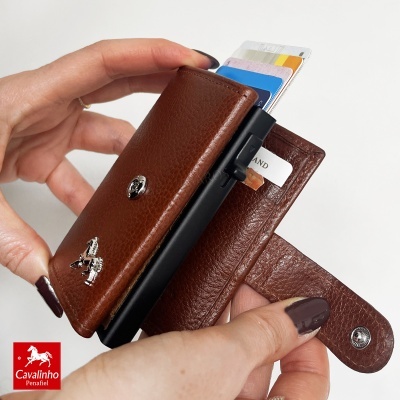 Carteira de pele castanha com fecho e slots para cartões mostrando cartão à extração