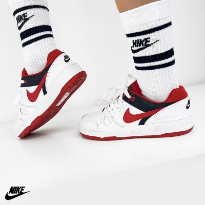 Ténis Nike brancos com detalhes vermelhos e pretos usados com meias brancas com riscas negras