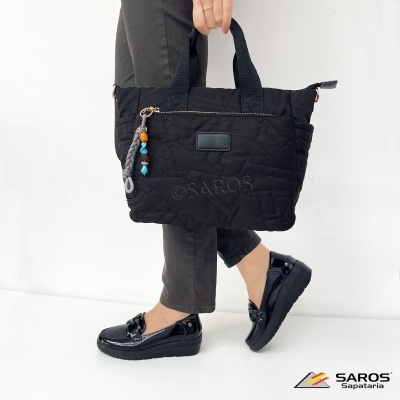 Mala preta acolchoada com pendente colorido e sapatos pretos brilhantes