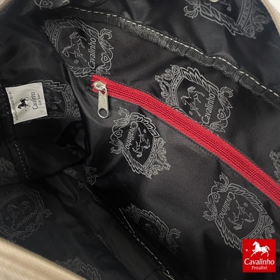 Interior de mala preta com padrão da Cavalinho e bolso com fecho vermelho