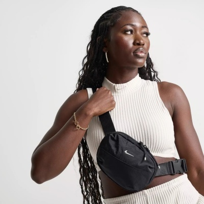 Mulher com conjunto branco canelado e pochete preta com logótipo Nike