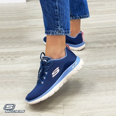 Ténis Skechers azuis com detalhes rosa e sola branca usados com calças de ganga azuis.